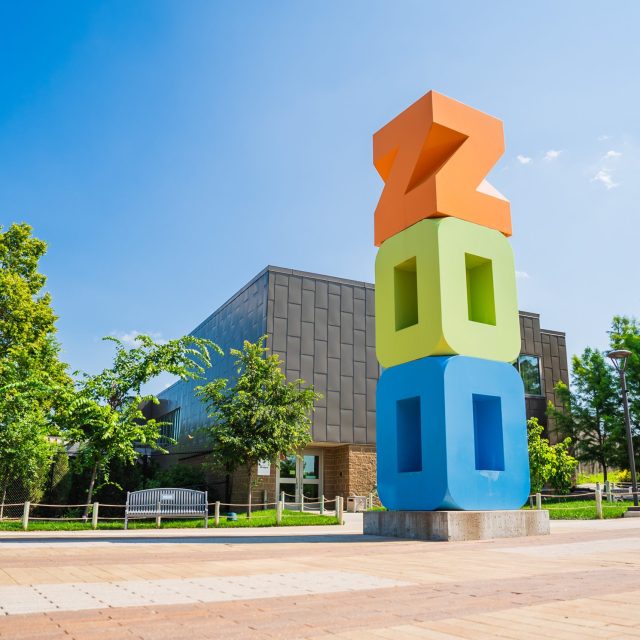 Large totem sculpture that spells ZOO in orange, green, and blue.