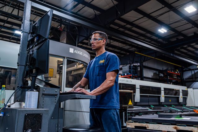 TMCO employee working at a computer at a warehouse.